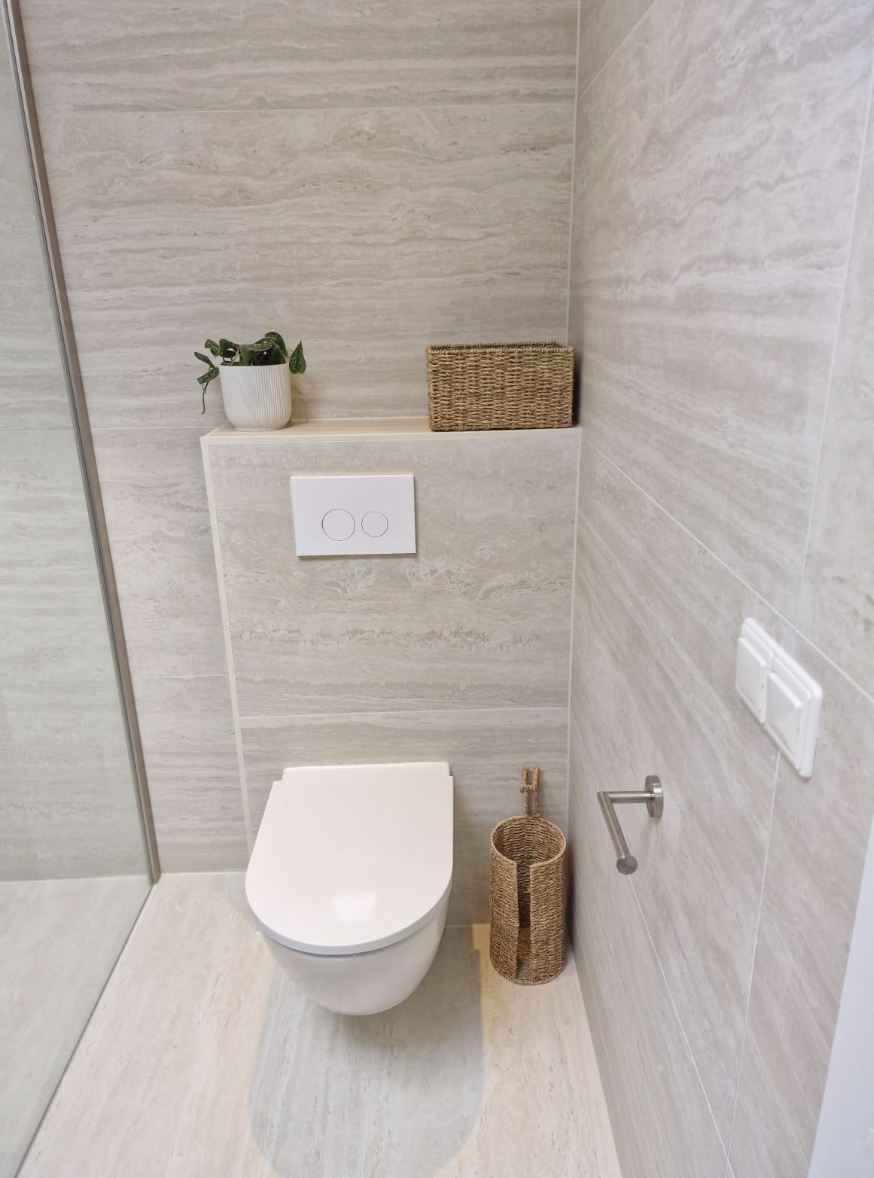 Toiletruimte met travertinlook tegels en natuurlijke accessoires